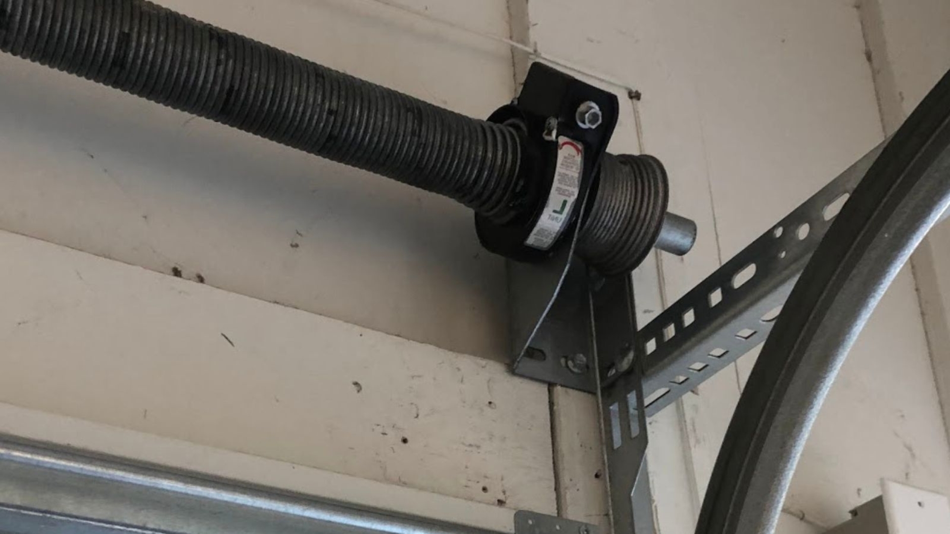 An industrial torsion spring on a commercial garage door