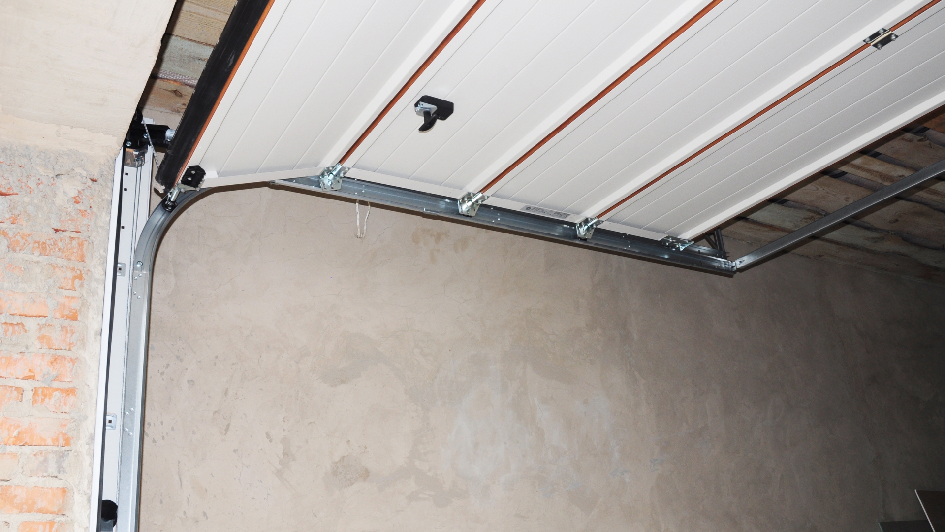 A low front headroom garage door lift