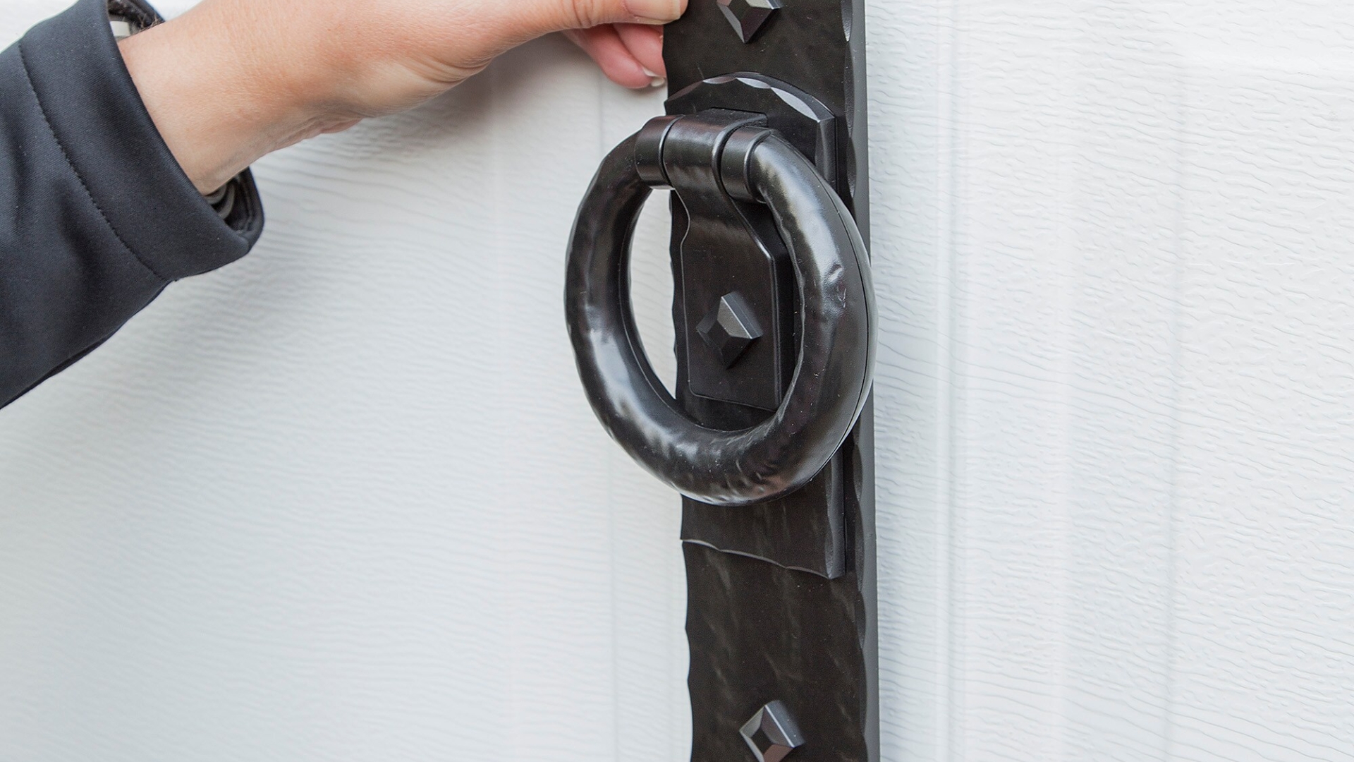 A homeowner installing garage door handles