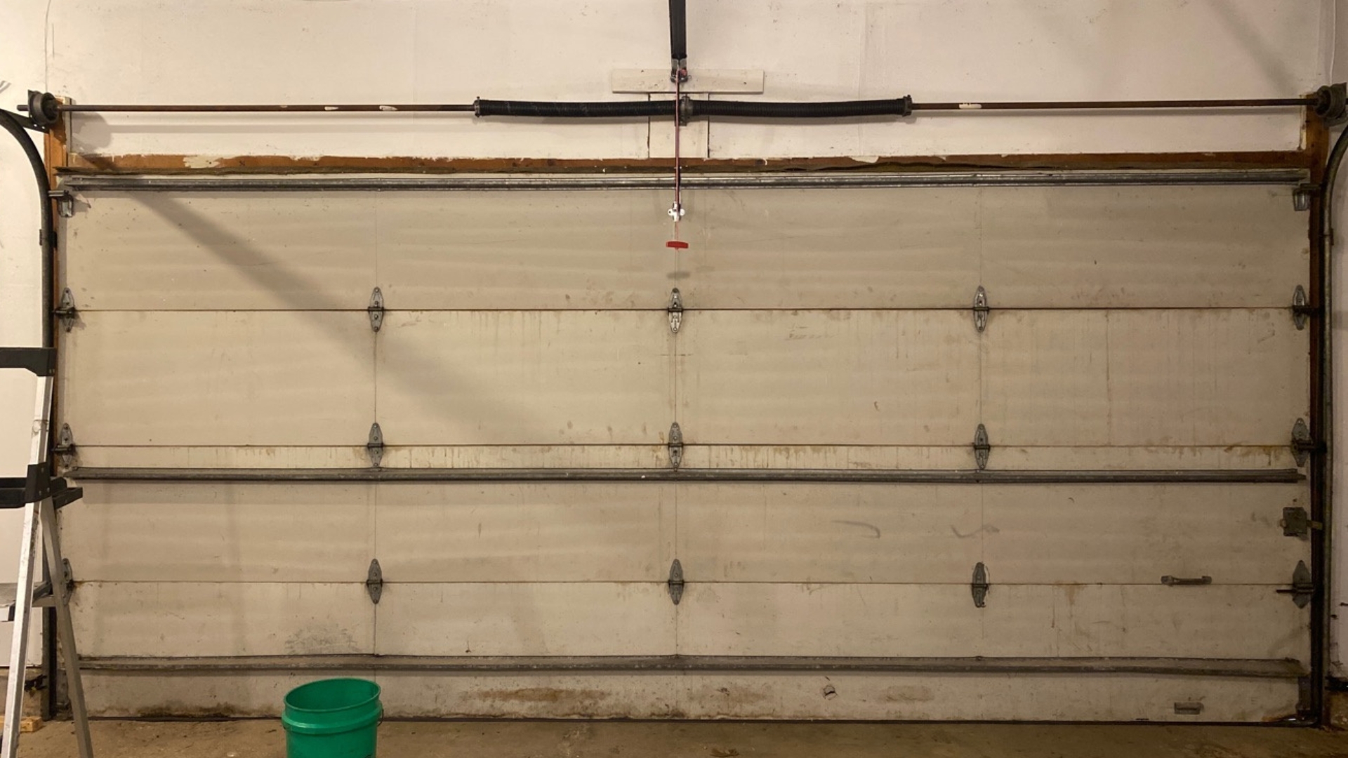 An old garage door with rusted garage door hinges and panels