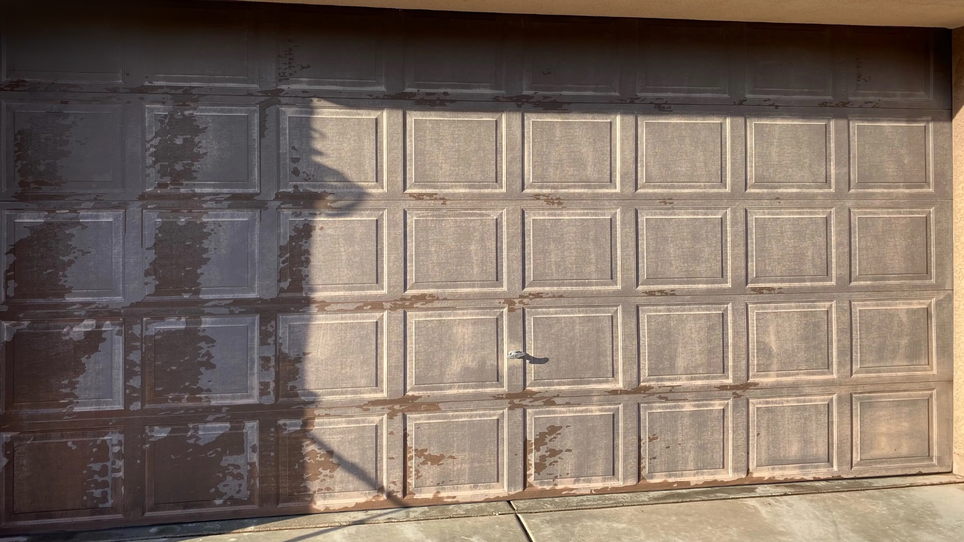 A residential sectional garage door that has a faded paint because of too much sun exposure