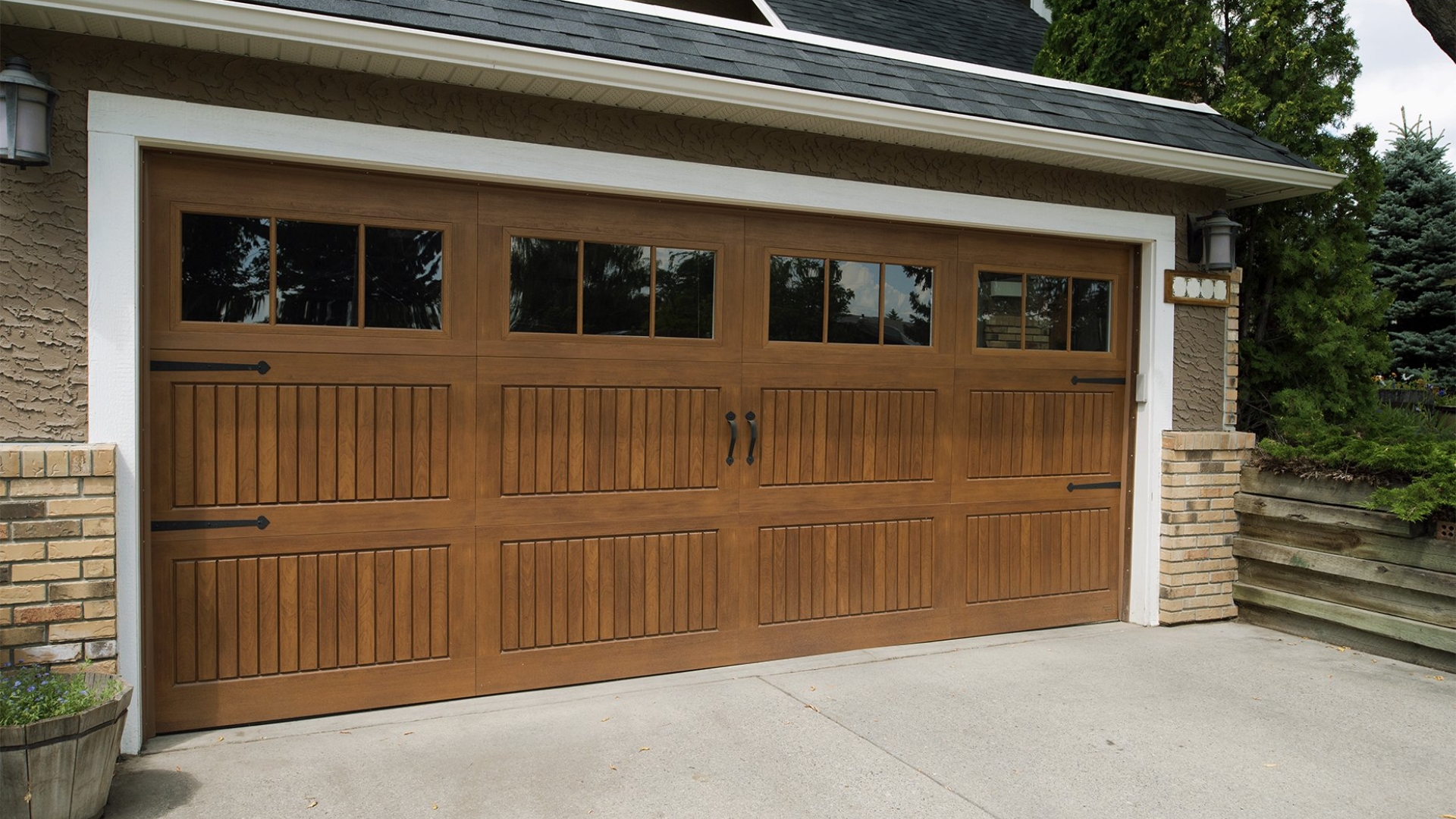 A residential garage door with decorative hinges, handles and windows