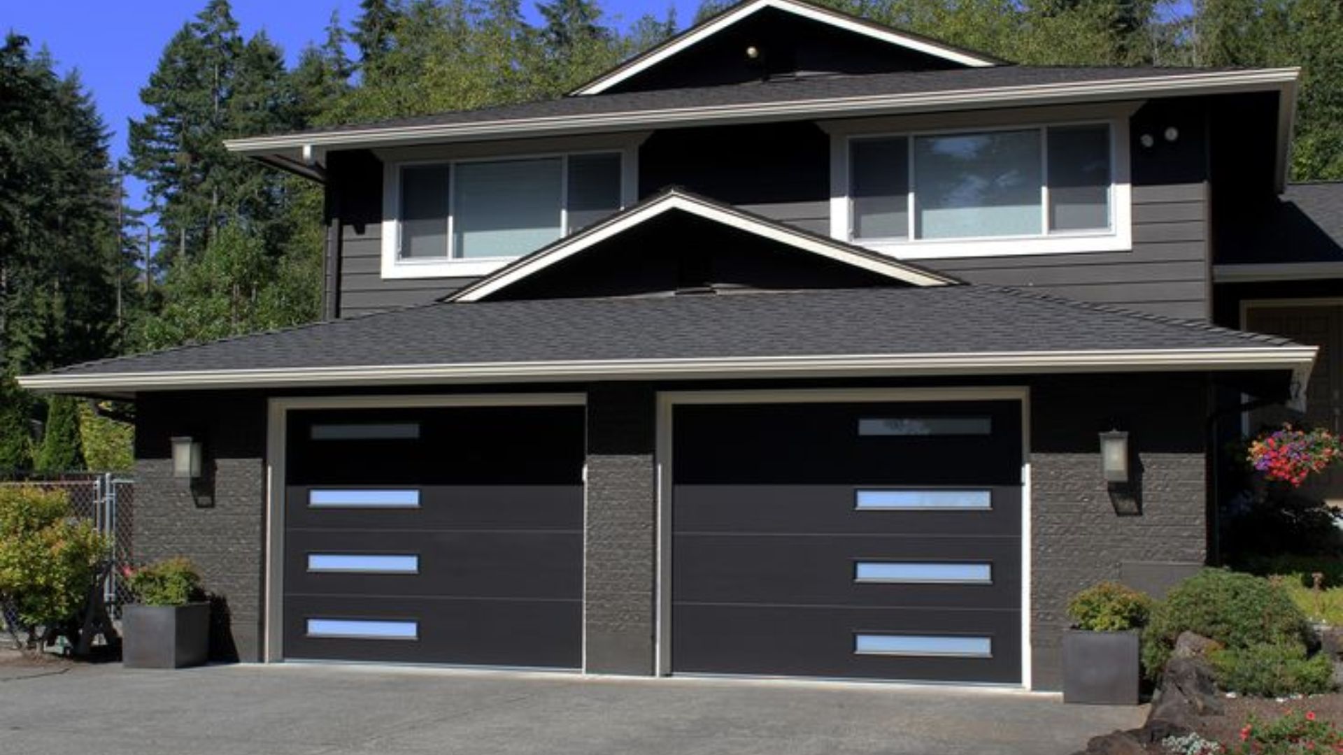 A residential home with two black thermal garage doors