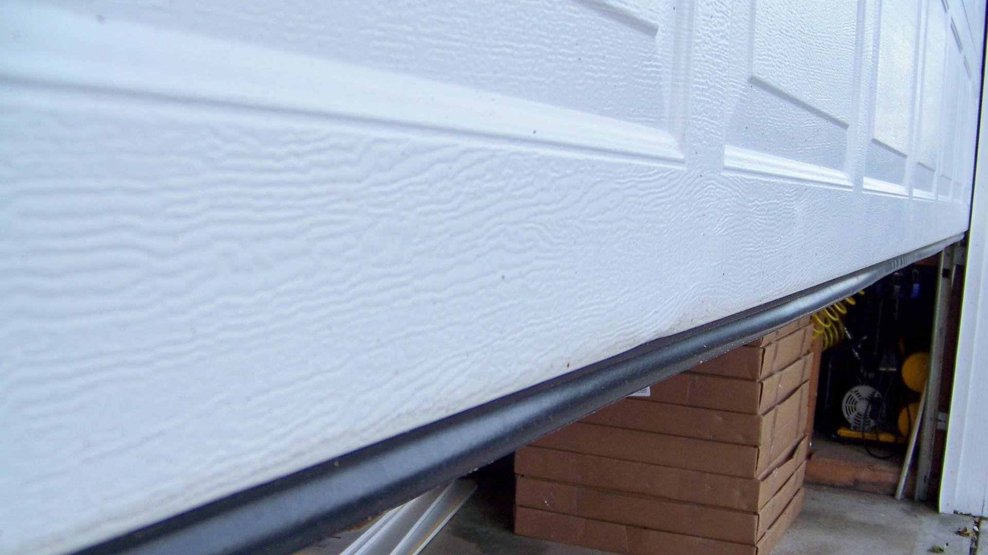 Securing bottom seals for garage door weatherproofing